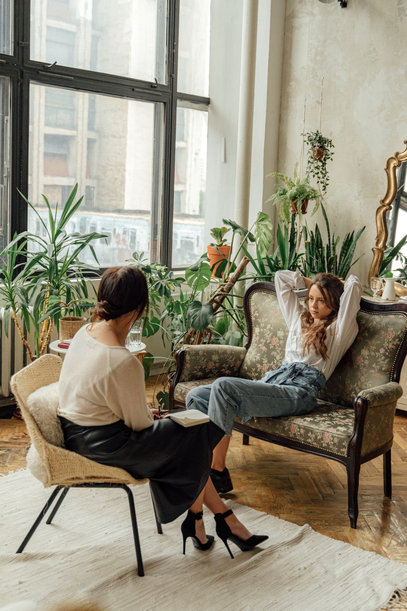 A supportive one-on-one conversation in a calm, plant-filled room