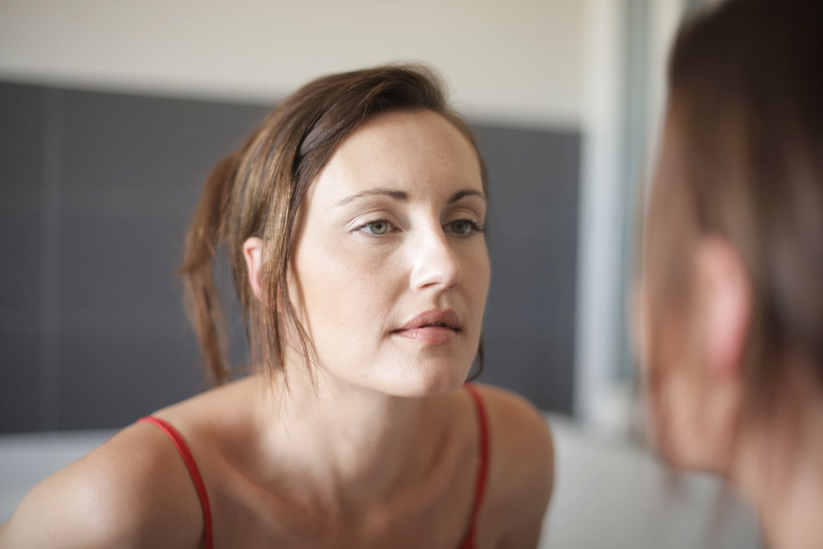 A woman studying her reflection in a mirror
